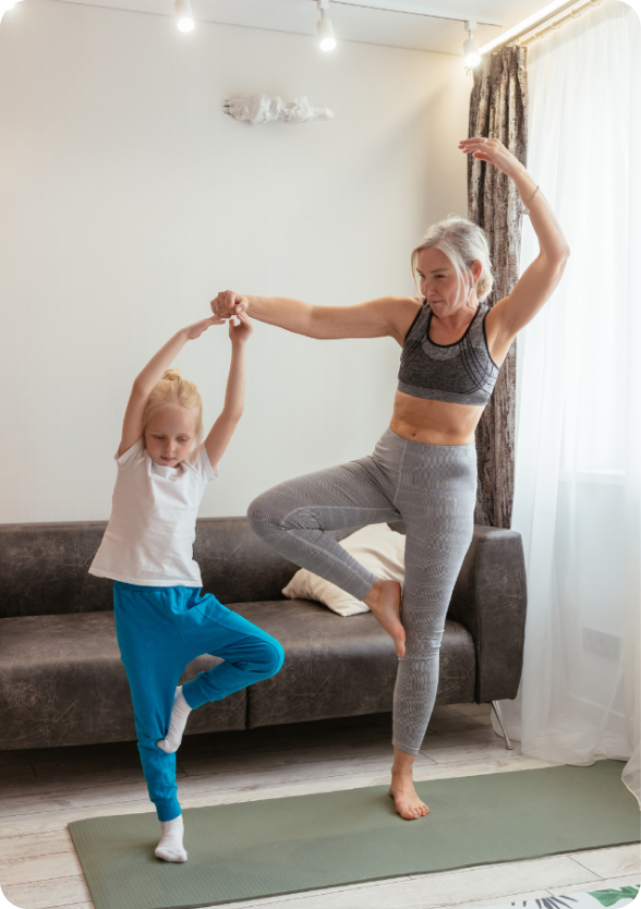 mother doing yoga poses with child in living room