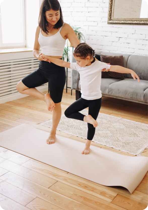 mother doing yoga poses with child in living room